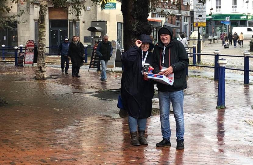 Lynn and Steve, our Campaign Manager in the town centre. Selling poppies in very wet and windy weather. Champions!