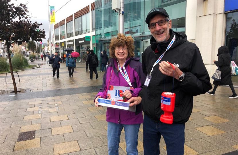 Cllr Penny and our 200 Club Top Chap out selling poppies in the rain. They look happy and both are smiling.