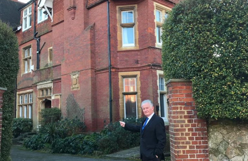 Councillor Robert Smart pictured outside a large residential building.