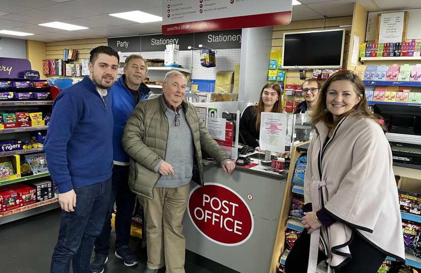 Caroline Ansell MP with Cllrs. David Small, Nick Ansell and Colin Belsey making use of the Rodmill Post Office. Featured with a staff member at the counter.
