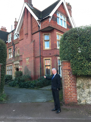 Councillor Robert Smart pictured outside a large residential building.